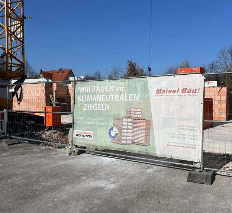 Blick auf einen Rohbau mit Betonwänden und einer offenen Tür zur Baustelle.